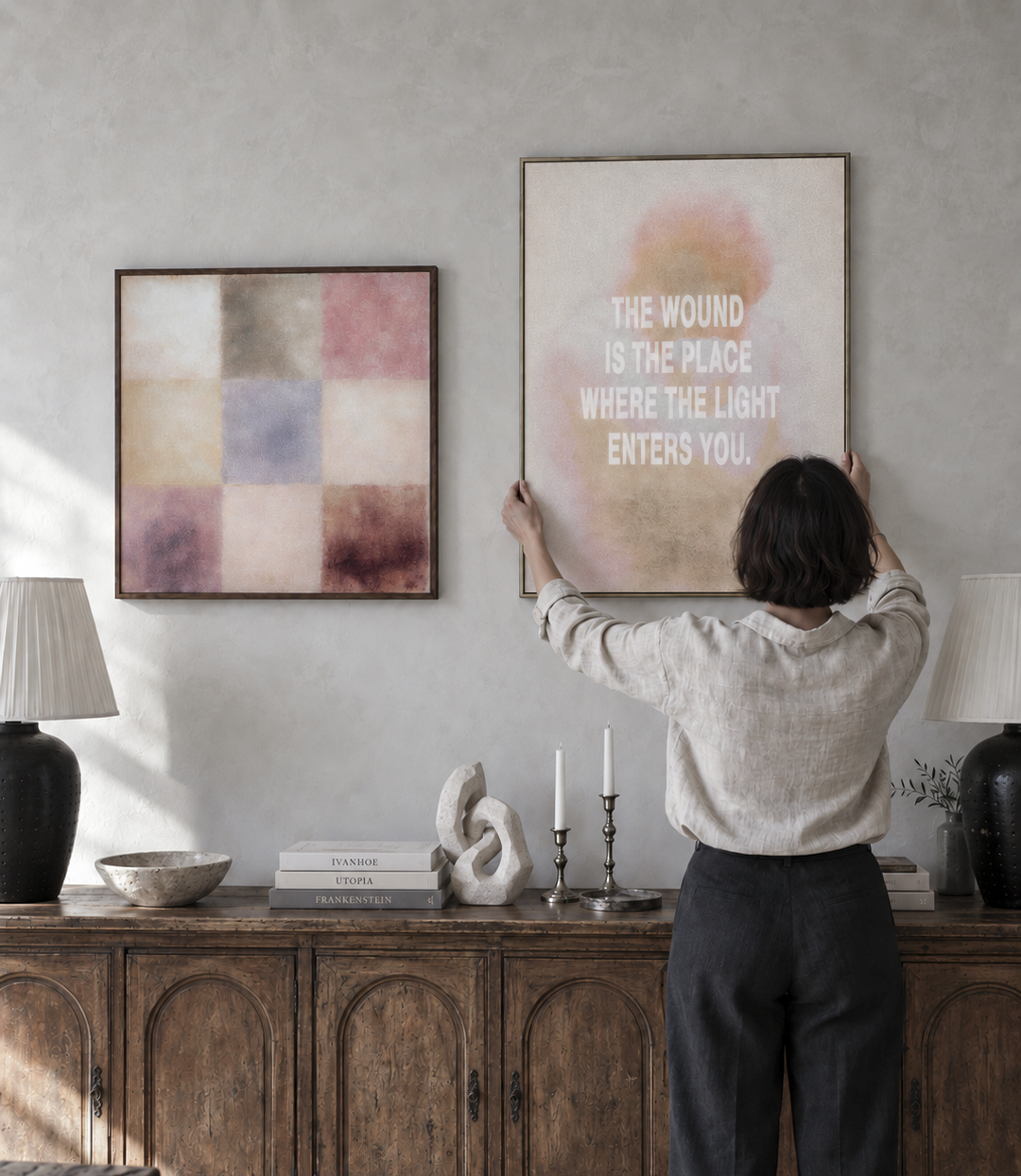 A woman arranging CapturedLoom artwork above a vintage wooden sideboard