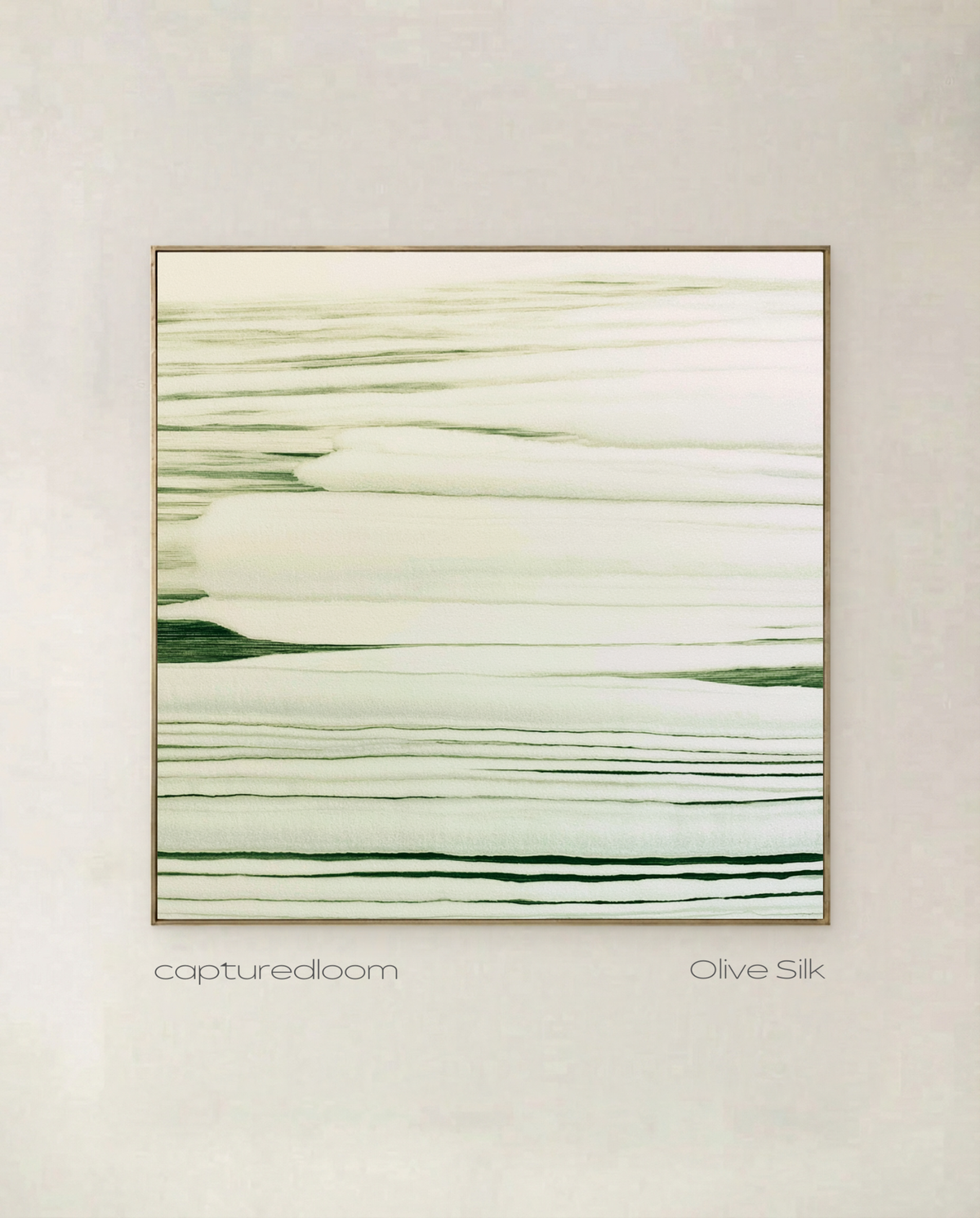Olive Silk - fine olive lines pulled horizontally across warm cream, shown in a thin gold frame on a pale wall