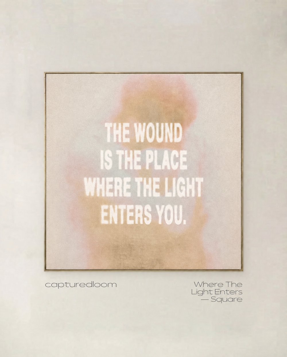 Where The Light Enters, square format - typographic art print in blush and gold, shown in a thin gold frame on a pale wall